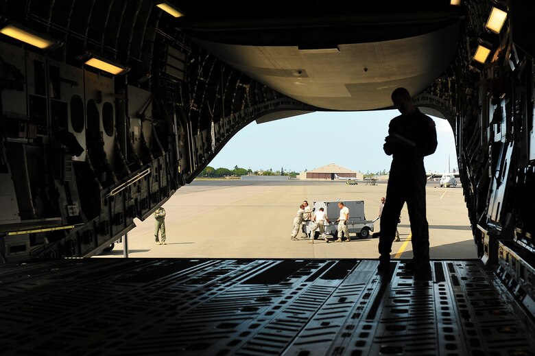 JOINT BASE PEARL HARBOR-HICKAM, Hawaii -- Staff Sgt. Paul Trowbridge, 535th Airlift Squadron loadmaster, supervisors the loading of a C-17 Globemaster III during Beverly Kahuna 2010-F, an Initial Response Readiness Exercise Oct. 20-21. During the exercise, more than 200 Airmen were processed through a deployment line, eight C-17 missions were generated and 140 short tons of cargo was moved while practicing the "deployment machine." This exercise concentrated on the basic "blocking and tackling" of getting cargo and people downrange. (U.S. Air Force photo/Staff Sgt. Mike Meares) 