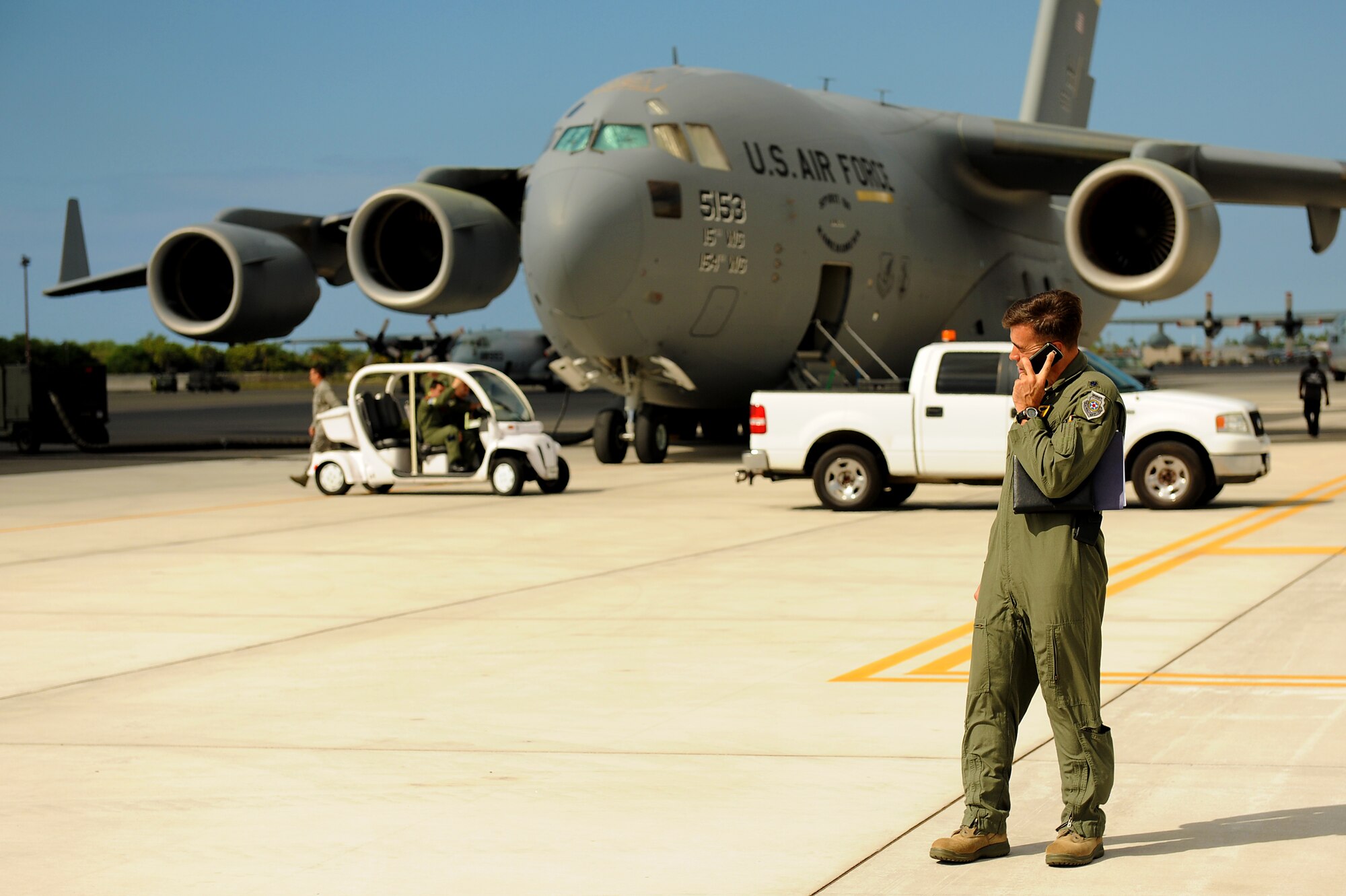 JOINT BASE PEARL HARBOR-HICKAM, Hawaii -- Lt. Col. George Fritts, 15th Wing inspector general, discusses communicates with his evaluation team while observing the loading of a C-17 Globemaster III Oct. 21 during Beverly Kahuna 2010-F, an Initial Response Readiness Exercise. During the exercise, more than 200 Airmen were processed through a deployment line, eight C-17 missions were generated and 140 short tons of cargo was moved while practicing the "deployment machine." This exercise concentrated on the basic "blocking and tackling" of getting cargo and people downrange. (U.S. Air Force photo/Staff Sgt. Mike Meares) 