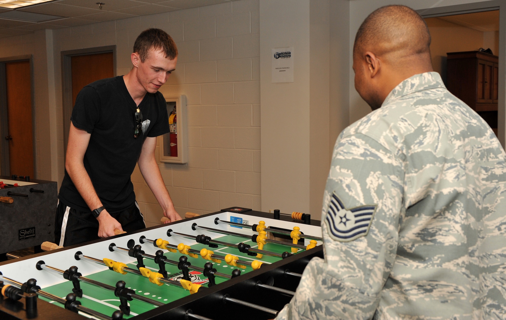 Airman 1st Class Damien Powell, 314th Operations Group intelligence analysis, and Tech. Sgt. Christian Fridge, 19th Civil Engineer Squadron non-commissioned officer in charge of dorm management, plays foosball at the Crossroads Café Oct 20. The café provides a variety of free activities and is a place for Airmen to spend time with friends during their down time. (U.S. Air Force photo by Senior Airman Gul Crockett)