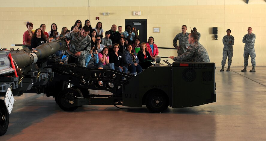 MOODY AIR FORCE BASE, Ga. -- Airmen from the 23rd Aircraft Maintenance Squadron, lifts a laser-guided bomb off a rack during the 23rd Maintenance Group’s Spouse Orientation Day Oct. 22. After the demonstration, spouses had an opportunity to view the A-10C Thunderbolt II up-close. (U.S. Air Force photo/Airman 1st Class Joshua Green)
