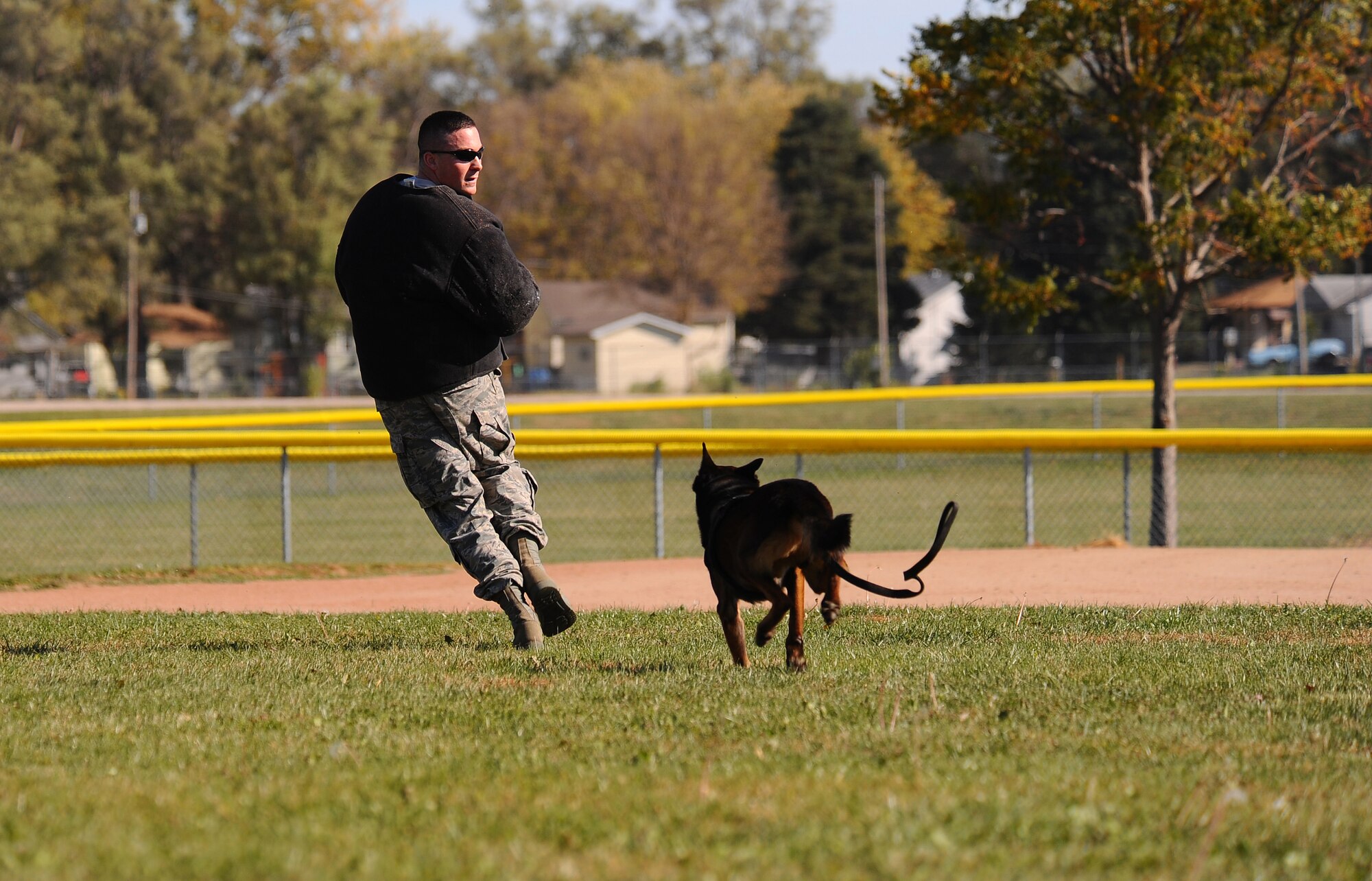 OFFUTT AIR FORCE BASE, Neb. - Senior Airman Steve Hanks, a military working dog handler with the 55th Security Forces Squadron, runs from Nero, his German sheppard working dog during a demonstration at the youth baseball fields here Oct. 20.  The demonstration was part of a base wide tour for high school and college students ready to enlist in the Air Force.
U.S. Air Force photo by Josh Plueger
