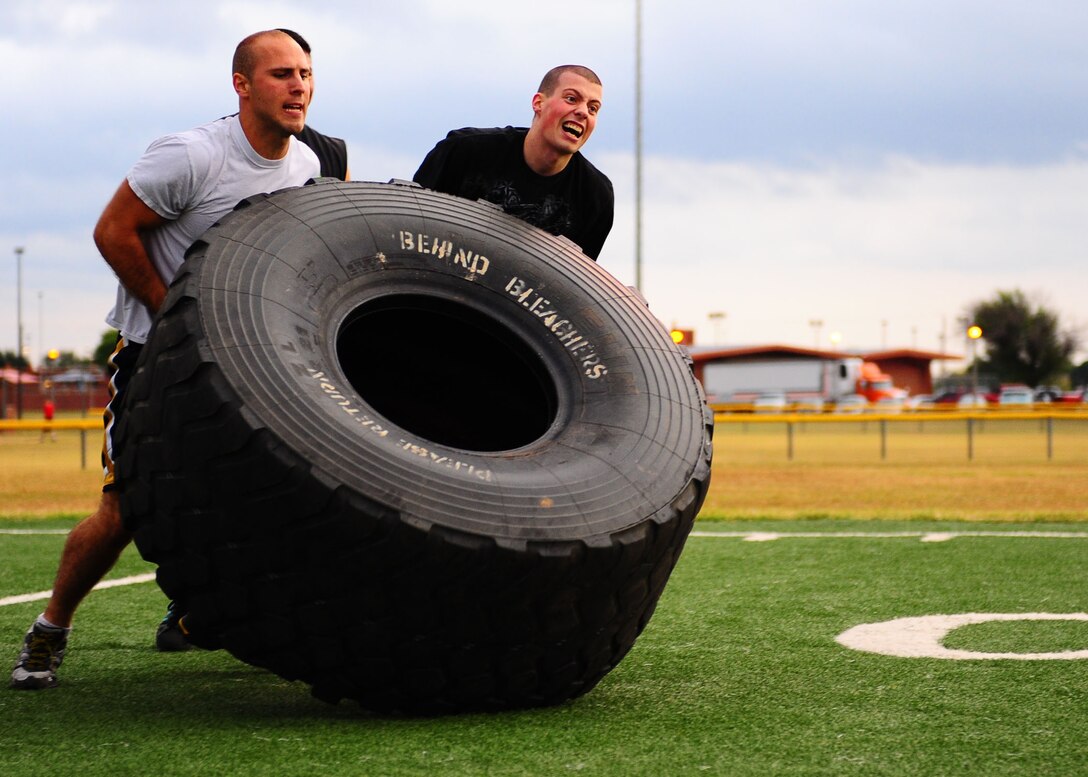 DYESS AIR FORCE BASE, Texas—Airman 1st Class Robert Hawlik (left), and Airman 1st Class Rocco Anzano (right), both 7th Component Maintenance Squadron, lift a giant tire during the Dyess Olympics Oct. 22 at the fitness center here. Dyess Olympics takes place each year to promote fun and boost moral for the base. It includes sports such as volleyball, base ball, basketball and more. (U.S. Air Force photo/ Airman 1st Class Brittney Smolinski)