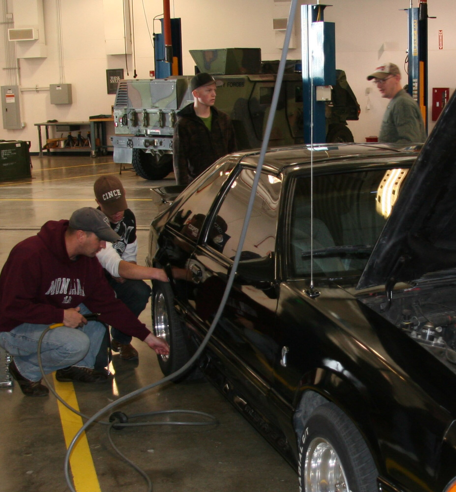 From left, Tech. Sgt. Barry Love, Airmen 1st Class  James Skare and Brian Jordan, as well as Tech. Sgt.  Lloyd Fletcher-Boggs inspect a privately owned vehicle's tires and exterior lights Oct. 17 at building 870. The Airmen will be on hand again Oct. 23 and 24 to conduct free inspections on POVs from 8 a.m. to 12 p.m. (U.S. Air Force photo/Staff Sgt. Dillon White)