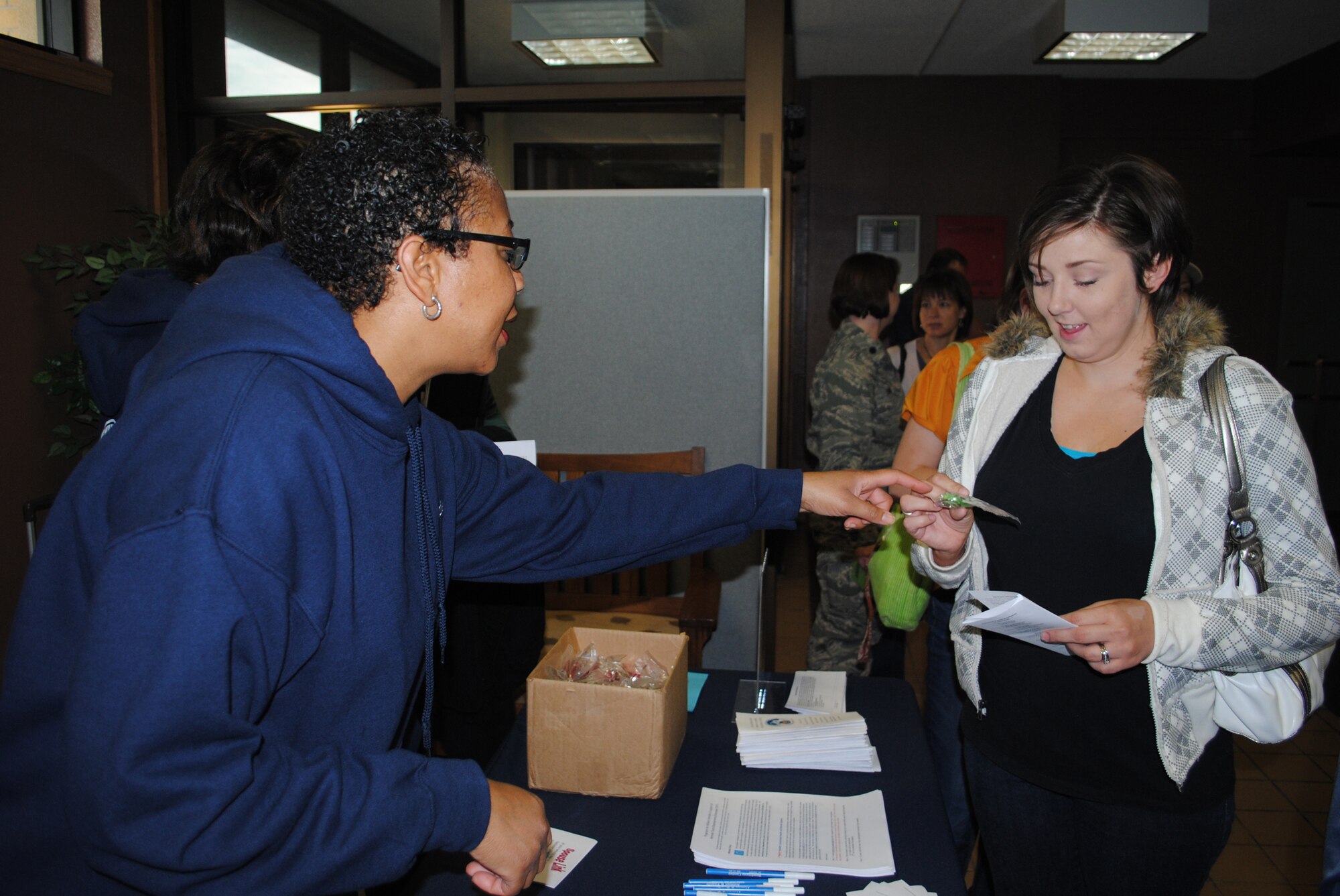 Jamie-Lynn Smith, 341st Force Support Squadron community readiness consultant, talks with Malmstrom spouse Heather White about some of the programs available through the Airman and Family Readiness Center and provides her with some informational material that was available at the Spouses’ Call Oct. 12. (U.S. Air Force photo/Airman 1st Class Kristina Overton)