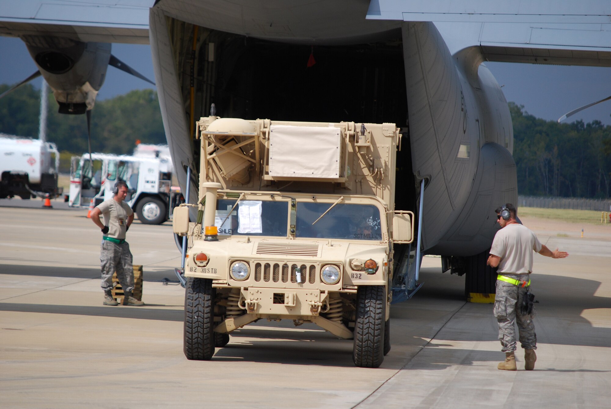 Two 615th CRW aerial porters guide an Army humvee into a waiting C-130. (U.S. Air Force Photo/Capt Paradon Silpasornprasit)