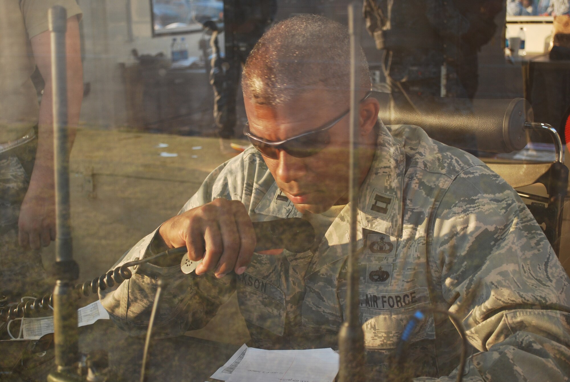 Captain Jim Jackson, 570th Global Mobility Readiness Squadron, coordinates airfield operations from inside a deployable communications shelter. 