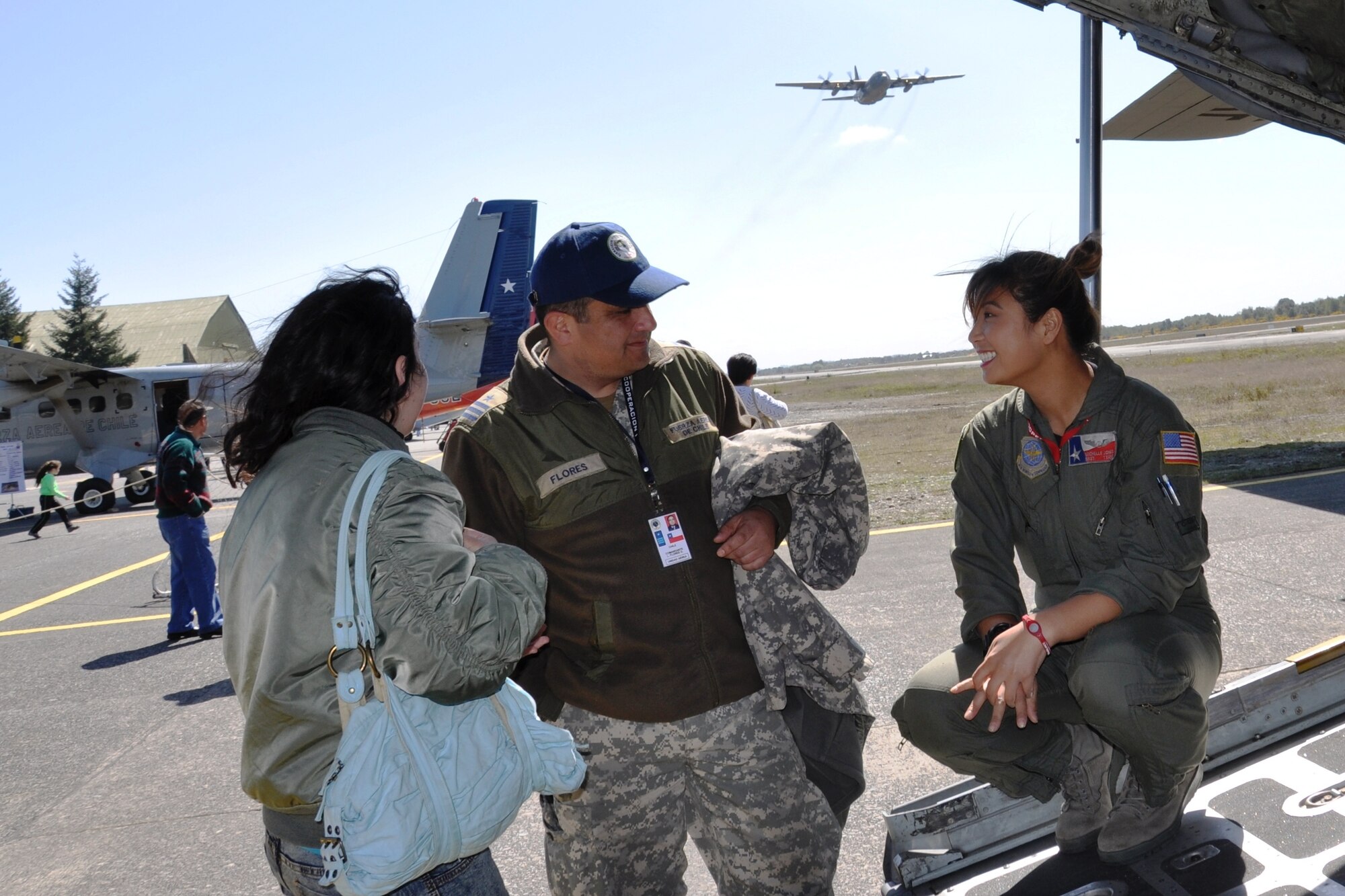 Staff Sgt. Michelle Jones, loadmaster with the 136th Airlift Wing, Texas Air National Guard, talks with Comandante L. Flores (Chilean Air Force) and his daughter about Sgt. Jones' work as a crew member on a C-130 Hercules and opportunities for females in the military at an open house.  The Oct. 8 Open House was part of a SICOFAA exercise (Sistema de cooperacion de las Fuerzas Aerias de las Americas), Cooperation 1 headquartered in Puerto Montt, Chile, Oct. 4 to 14. The exercise scenario involved using the air forces of SICOFAA member nations for humanitarian assistance after a natural disaster (U.S. Air Force photo/Capt. Rebecca A. Garcia).