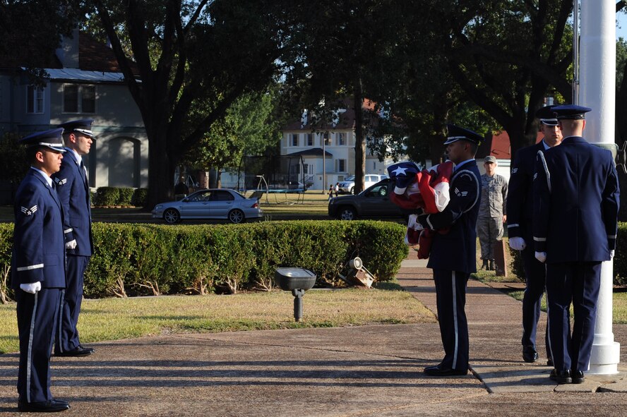 BARKSDALE AIR FORCE BASE, La. -- Members of the 2nd Bomb Wing Honor Guard performs a flag folding ceremony during retreat Oct. 20. The retreat ceremony serves a two-fold purpose -- it signals the end of the official duty day and pays respect to the flag. (U.S. Air Force photo/Senior Airman Brittany Y. Bateman)(RELEASED)