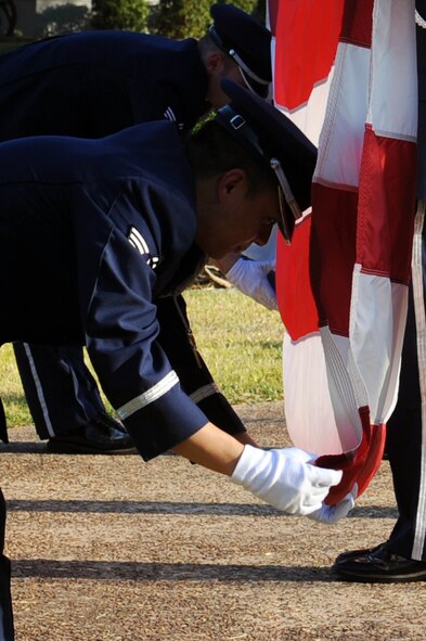BARKSDALE AIR FORCE BASE, La. -- Members of the 2nd Bomb Wing Honor Guard performs a flag folding ceremony during retreat Oct. 20. The retreat ceremony serves a two-fold purpose -- it signals the end of the official duty day and pays respect to the flag. (U.S. Air Force photo/Senior Airman Brittany Y. Bateman)(RELEASED)