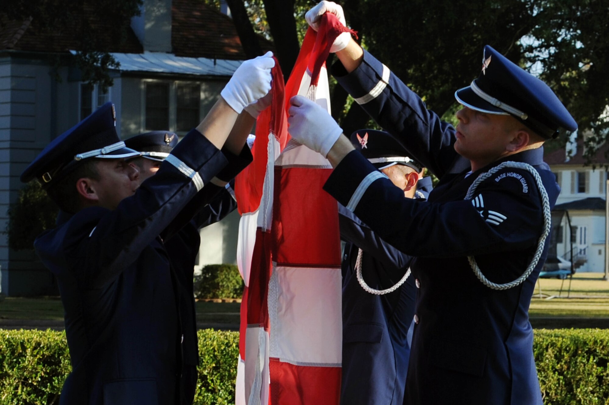 BARKSDALE AIR FORCE BASE, La. -- Members of the 2nd Bomb Wing Honor Guard performs a flag folding ceremony during retreat Oct. 20. The retreat ceremony serves a two-fold purpose -- it signals the end of the official duty day and pays respect to the flag. (U.S. Air Force photo/Senior Airman Brittany Y. Bateman)(RELEASED)