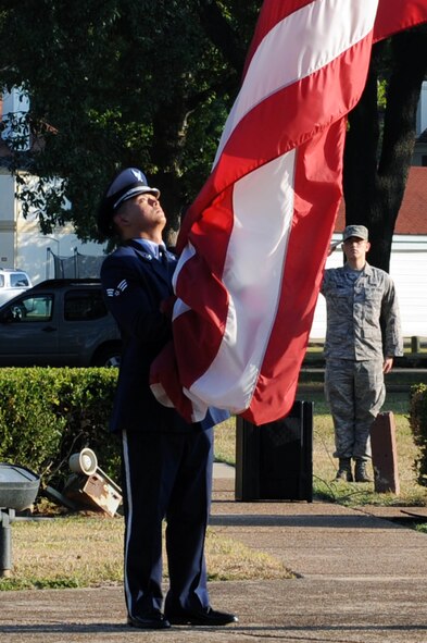 BARKSDALE AIR FORCE BASE, La. -- Members of the 2nd Bomb Wing Honor Guard lowers the flag during a retreat ceremony, Oct. 20. The retreat ceremony serves a two-fold purpose -- it signals the end of the official duty day and pays respect to the flag. (U.S. Air Force photo/Senior Airman Brittany Y. Bateman)(RELEASED)