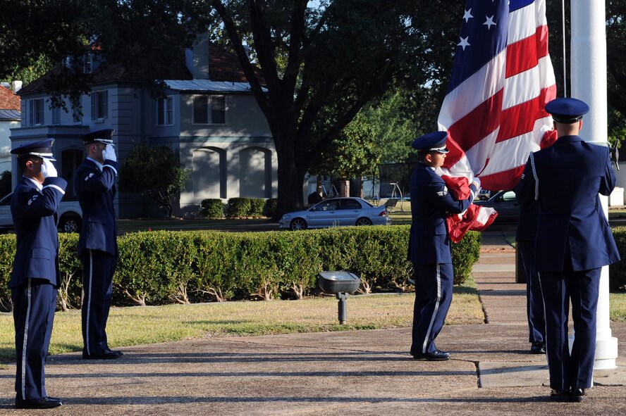 BARKSDALE AIR FORCE BASE, La. -- Members of the 2nd Bomb Wing Honor Guard lower the flag during a retreat ceremony, Oct. 20. The retreat ceremony serves a two-fold purpose -- it signals the end of the official duty day and pays respect to the flag. (U.S. Air Force photo/Senior Airman Brittany Y. Bateman)(RELEASED)