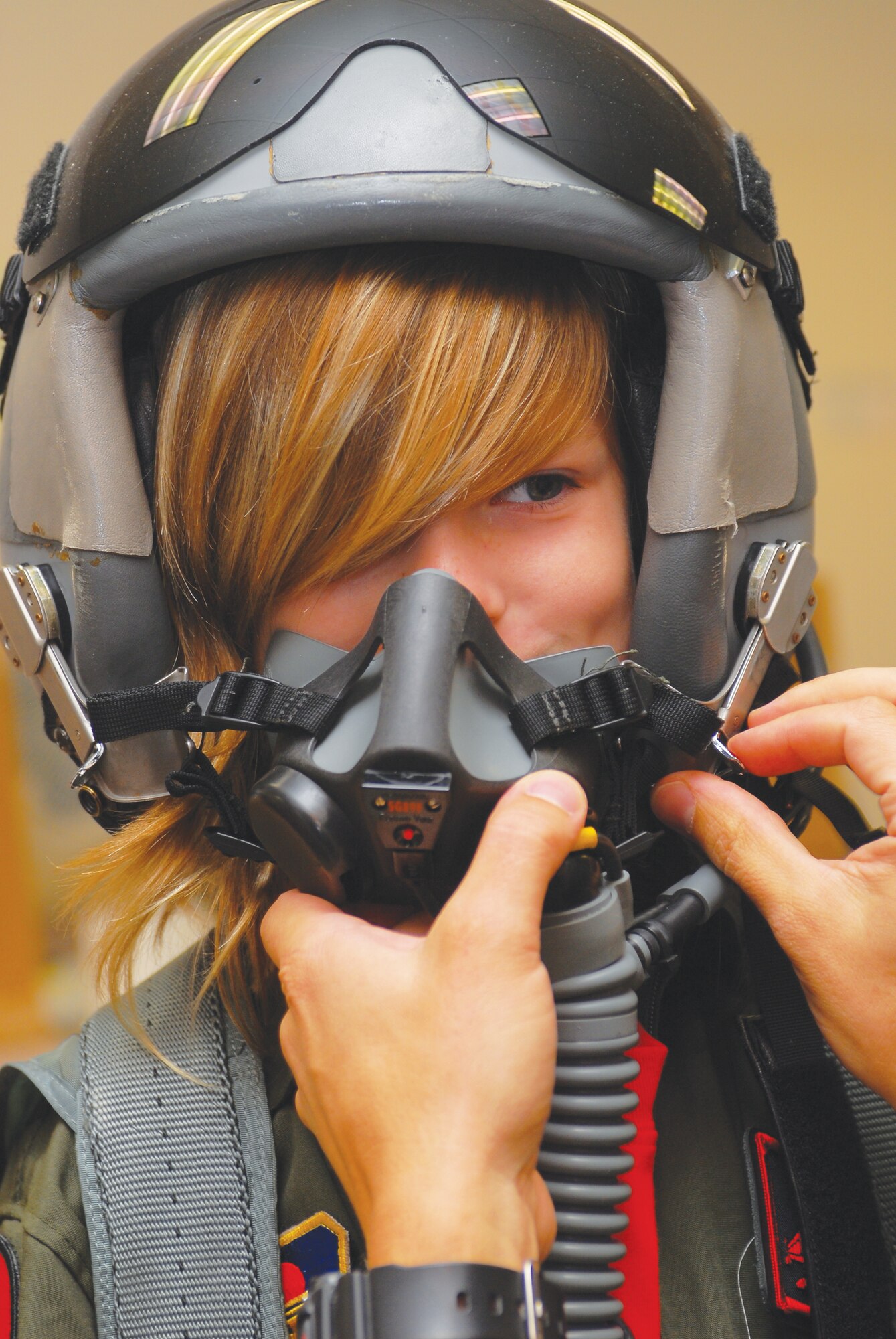 Pilot-For-A-Day Emilith Carroll, 9, tries on a pilot's helmet in the life support section of the 425th Fighter Squadron, Luke Air Force Base, Arizona on October 12th during her tour of Luke.  (U.S. Air Force photo/Senior Airman Tracie Forte)