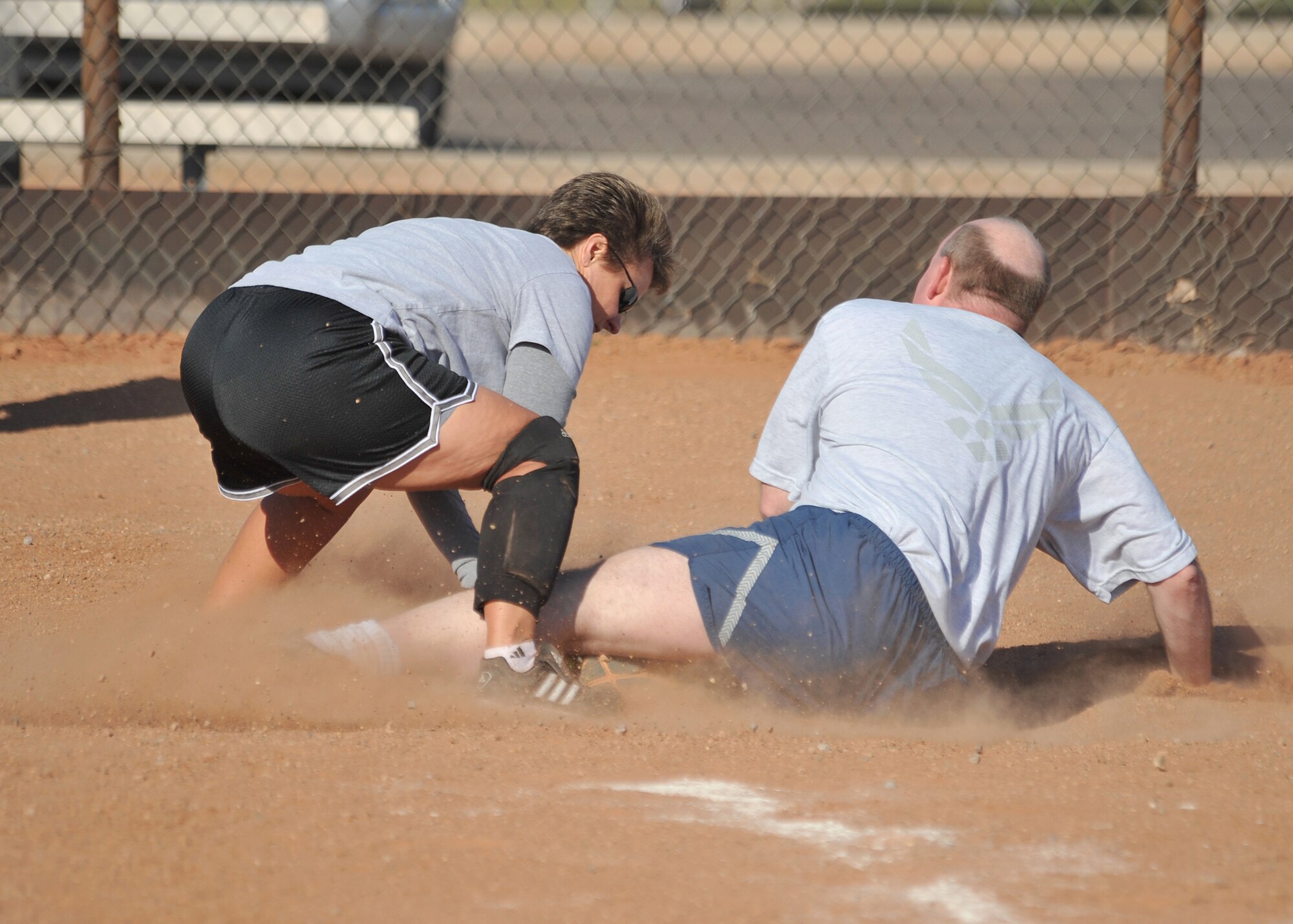 Lt. Col. Todd Alan, 377th Mission Support Group, slides into home plate as Laura Armstrong 498th, tries to tag him out, Oct. 13, during a Wing Sports Day softball event.  U.S. Air Force Photo by Todd Berenger