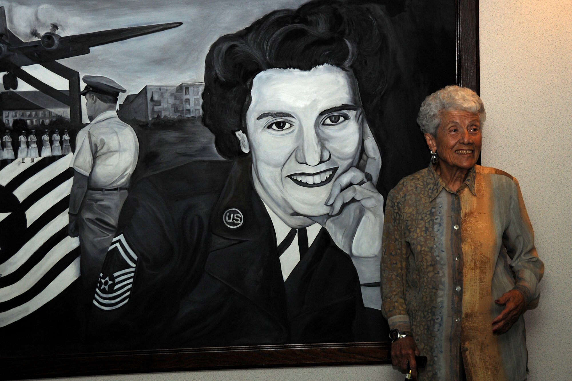 Retired Chief Master Sgt. Grace Peterson stands in front of a painting of herself in front of the Grace Peterson Hall here Oct. 18 at Joint Base McGuire-Dix-Lakehurst, N.J.  Chief Peterson was the first female Airman to be promoted to the Air Force’s highest enlisted grade in 1960. She visited the U.S. Air Force Expeditionary Center this week to see the facility that bears her name. (U.S. Air Force photo by Staff Sgt. Veuril McDavid/Released)