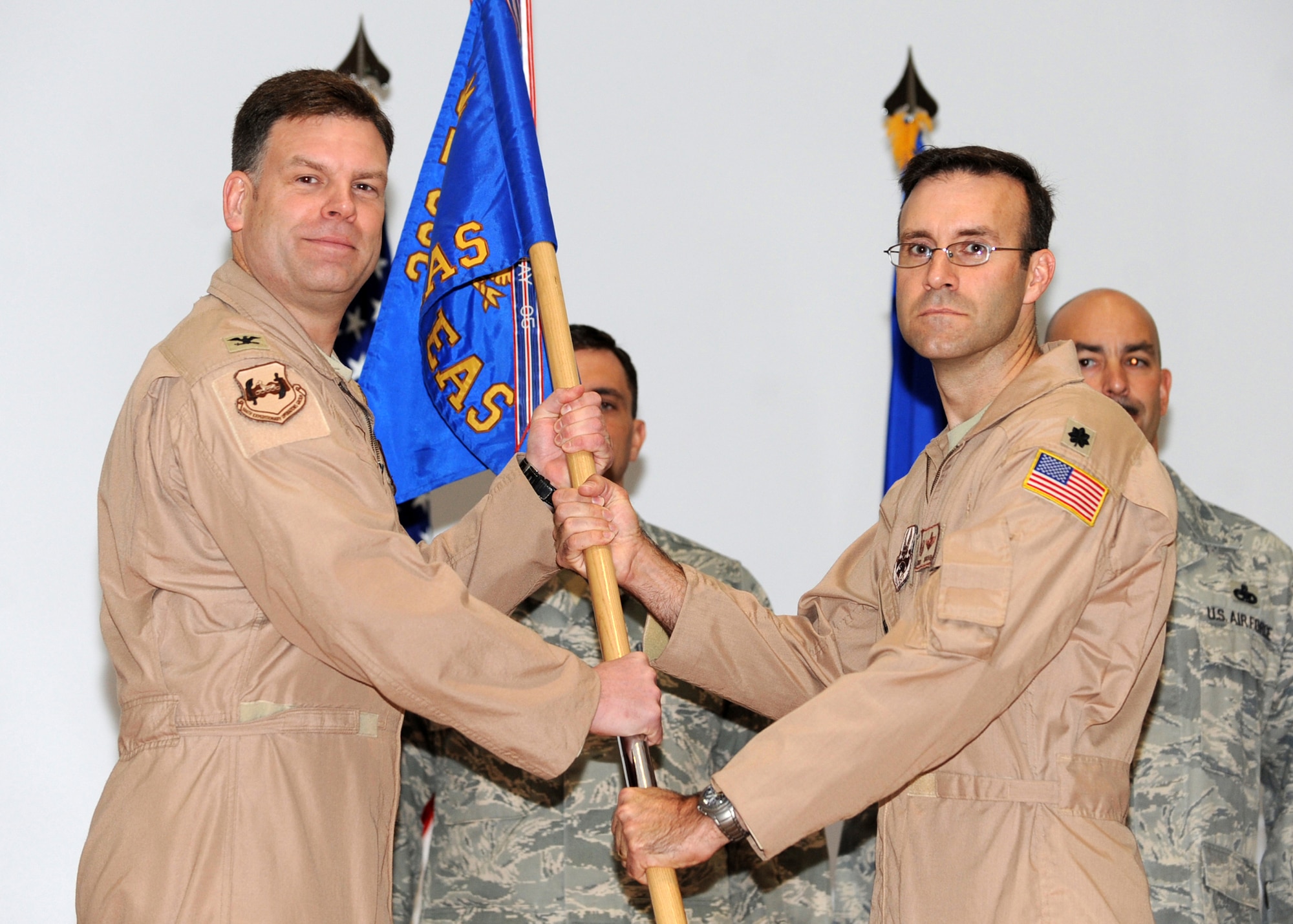 SOUTHWEST ASIA - Col. Scott Brewer (left), 386th Expeditionary Operations Group commander, passes the 737th Expeditionary Airlift Squadron guidon to Lt. Col. David Kincaid, the new 737th EAS commander, during a change-of-command ceremony at an undisclosed air base here Oct. 15, 2010. Colonel Kincaid assumed command after Lt. Col. Keith Green relinquished command. (U.S. Air Force photo by Senior Airman Laura Turner/Released)