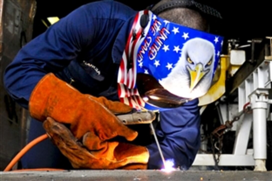 U.S. Navy Seaman Kyle Garcia welds a ramp on the fantail of the aircraft carrier USS George Washington in the Pacific Ocean, Oct. 21, 2010. The George Washington, the Navy's only permanently forward-deployed aircraft carrier, is under way to help ensure security and stability in the western Pacific Ocean. Garcia is a hull maintenance technician.