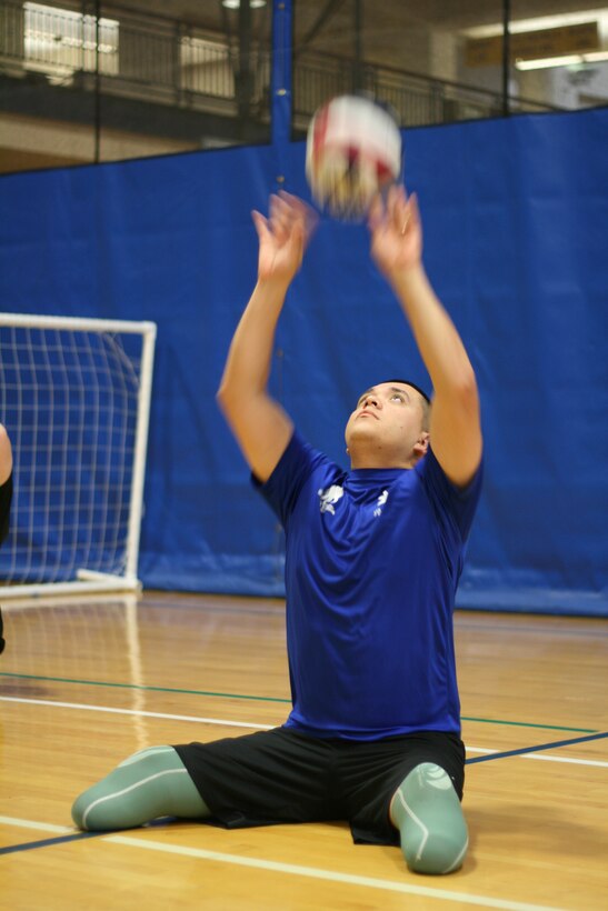 Corporal Jose D. Gasca practices setting the volleyball during a sports camp here Friday.  The training camp is the second of six hosted by the Wounded Warrior Regiment’s Warrior Athlete Reconditioning program.  Wounded, ill and injured Marines spent three days training in wheelchair basketball and sitting volleyball.