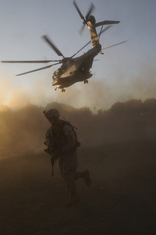 2nd Lt. Luis Spradley, platoon commander with E Company, 2nd Battalion, 7th Marine Regiment, runs to his objective while a CH-53E Super Stallion takes off from Kiwanis Park in Yuma, Ariz., Oct. 22, 2010. The Marines, based at the Marine Corps Air Ground Combat Center Twentynine Palms, Calif., set up a security perimeter for the training operation, designed to keep control of the situation and ensure the safety of onlookers.