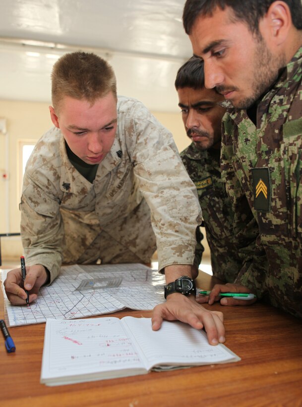 Sgt. Michael Mondt, the lead instructor with the Regimental Combat Team 1 Embedded Training Team, shows Afghan National Army Staff Sgts. Baz Mir and Noordin how to plot points on a six-digit grid, Oct. 23, during the first ANA instructor course at Camp Dwyer, Afghanistan. Mondt is from Winnemucca, Nev.