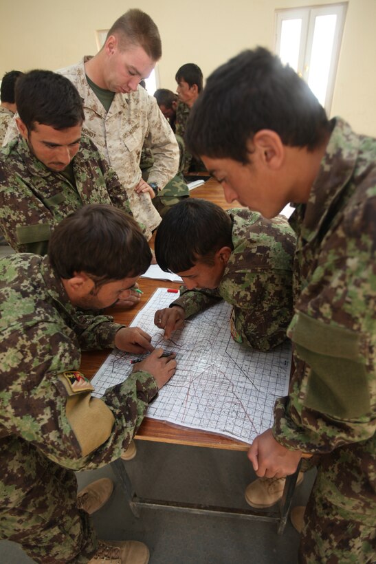 Sgt. Michael Mondt, the lead instructor with the Regimental Combat Team 1 Embeded Training Team, shows Afghan National Army soldiers how to plot points on a six-digit grid, Oct. 23, during the first ANA instructor course at Camp Dwyer, Afghanistan. Mondt is from Winnemucca, Nev.
