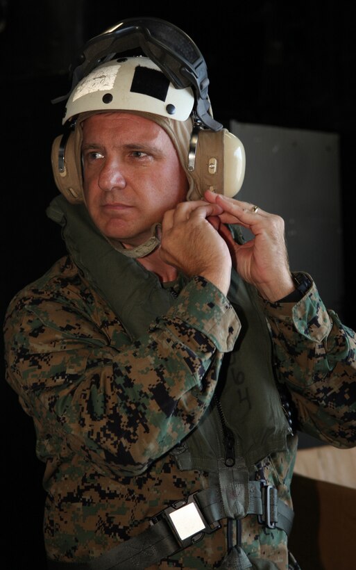 Lt. Col. Paul D. Baker, commanding officer of Marine Wing Support Squadron 271 from Marine Corps Air Station Cherry Point, N.C., puts on a cranial in preparation for his departure, Oct. 23, 2010, after visiting Marines and sailors of the Special-Purpose Marine Air-Ground Task Force Continuing Promise 2010. Baker embarked aboard USS Iwo Jima for two days to observe operations of the CP10 team.