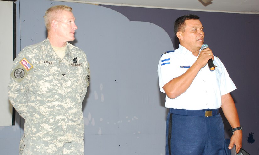 SOTO CANO AIR BASE, Honduras --  Col. Gregory Reilly (left), the Joint Task Force-Bravo commander, and Col. Wilfredo Reyes, the Honduran Air Force Academy commandant, greet foreign service nationals and their family members during FSN Family Day here Oct. 22. (U.S. Air Force photo/Capt. John Stamm)