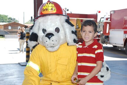SOTO CANO AIR BASE, Honduras --  The child of a foreign service national here poses with Sparky the Fire Dog during FSN Family Day here Oct. 22. FSNs and their families were treated to a tour of base facilities, to include the Soto Cano Fire Department. (U.S. Air Force photo/Capt. John Stamm)