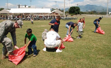 SOTO CANO AIR BASE, Honduras --  Quickly jumping in their bags, U.S. servicemembers, foreign service nationals and their family members participate in a sack race during FSN Family Day here Oct. 22. Besides a base tour, FSNs were awarded for their service to Soto Cano during the festivities. (U.S. Air Force photo/Capt. John Stamm)
