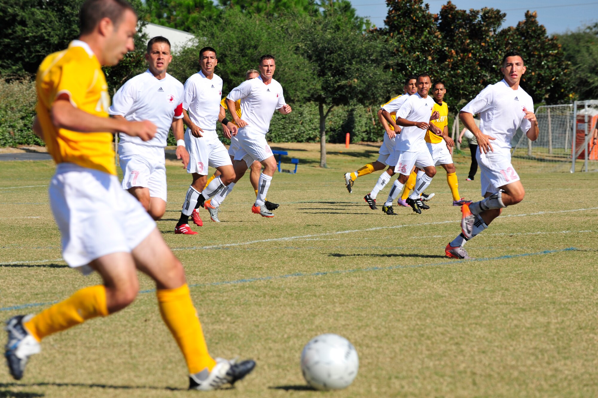 U.S. Navy Hospital Corpsman Petty Officer 1st Class Nathan Gavin, dribbles the ball downfield while the U.S. Marine soccer team players run interference during an Armed Forces Men's Soccer Championship Semifinal match at Morgan Sports Complex, Destin, Fla., Oct. 23, 2010. The Armed Forces Championships are conducted by the Armed Forces Sports council for the purpose of promoting, understanding, goodwill, and competition among the Armed Services. (DoD Photo by Staff Sgt. Stephanie Jacobs/RELEASED)
 