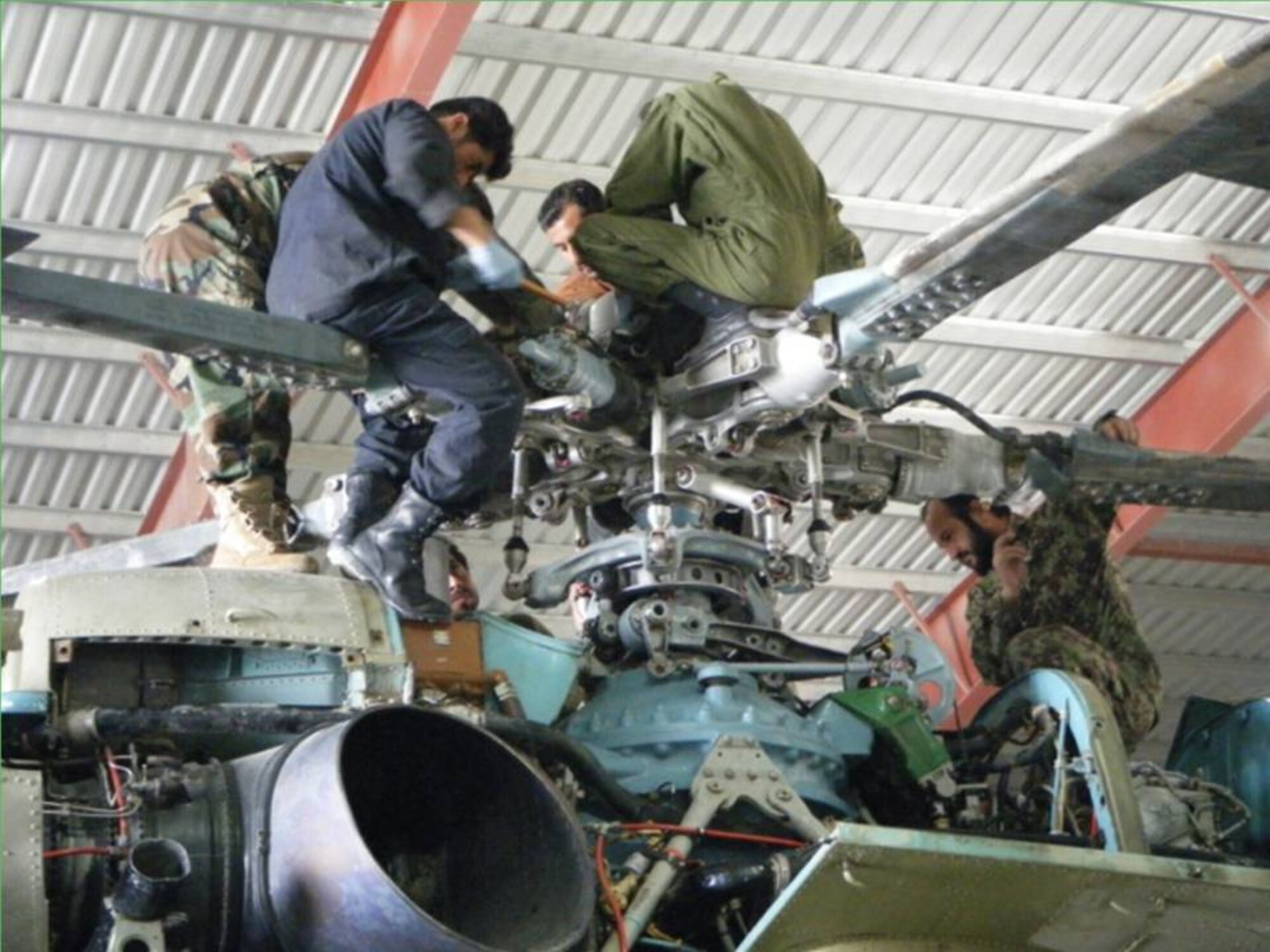 KANDAHAR, Afghanistan - Afghan Air Force Kandahar Air Wing maintainers and Kabul Tiger Team work together to complete a gear box inspection on Oct. 10, 2010. (U.S. Air Force photo/RELEASED).
