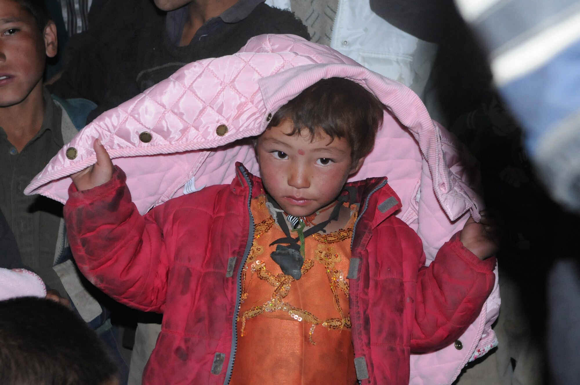 PANJSHIR PROVINCE, Afghanistan ? A young boy, from Astana Village, receives a winter coat donated by family and friends of the Panjshir Provincial Reconstruction Team, Oct. 6.  The coats were handed out by the village elders to approximately 150 children. Members of Panjshir PRT hiked 12 kilometers to the remote village of Astana to deliver humanitarian aid. The village of Astana isn?t reachable during the winter months due to large amounts of snow.  (USAF Photo by: Tech Sgt Sean Mateo White, PRT Panjshir photographer)(released)