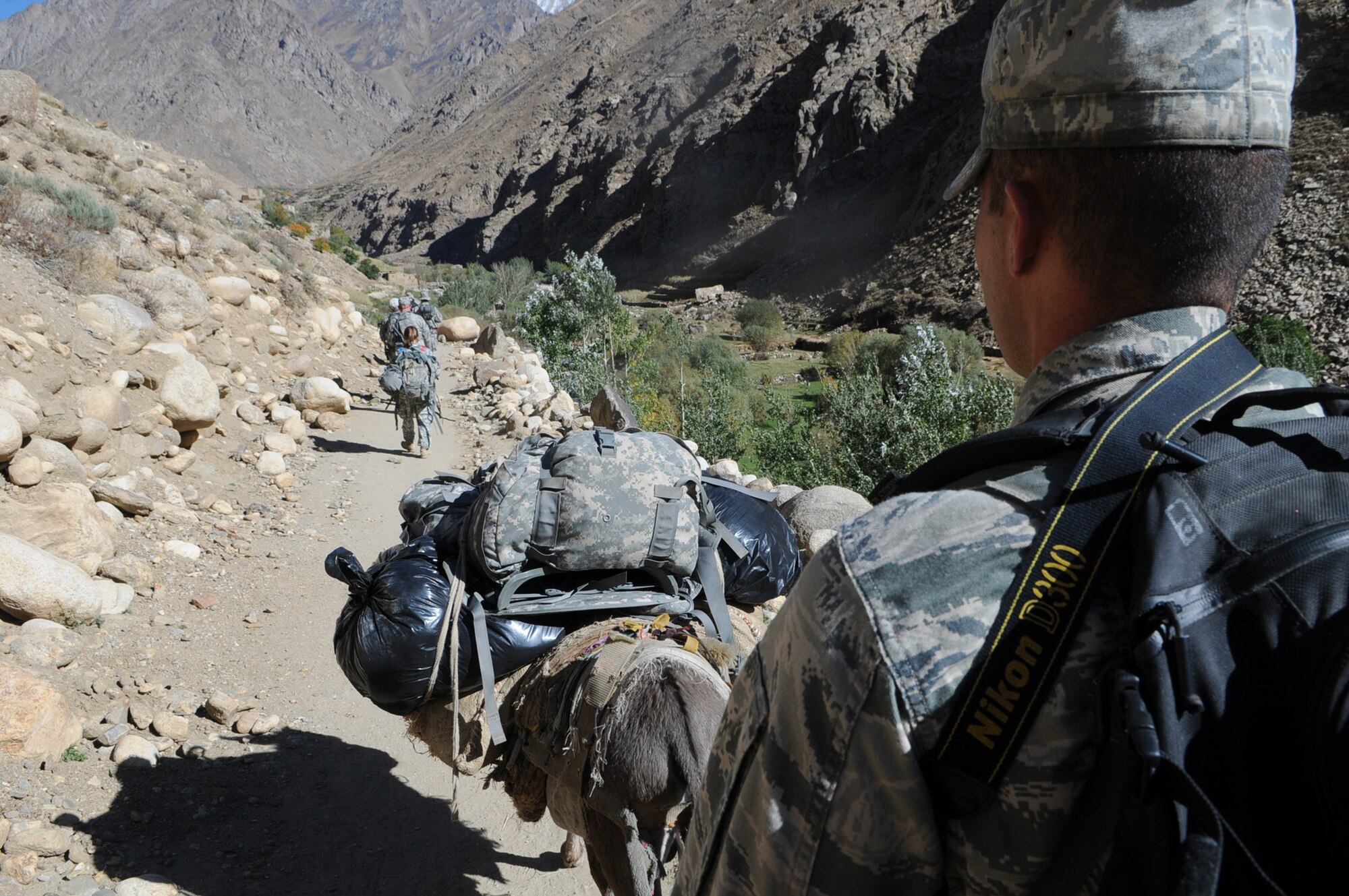 PANJSHIR PROVINCE, Afghanistan ? U.S. Air Force Capt. Phillip Baker, Panjshir Provincial Reconstruction Team civil engineer and San Antonio native, hikes along the 12-kilometer trail to the remote village of Astana, Oct. 6.  Members of Panjshir PRT hiked to the village to deliver winter coats and to talk to village elders about any other issues the village may be experiencing.  (USAF Photo by: Tech Sgt Sean Mateo White, PRT Panjshir photographer)(released)