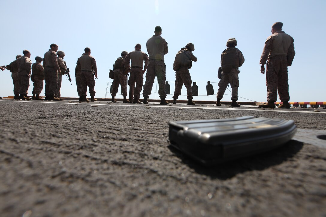 Marines with Command Element, 26th Marine Expeditionary Unit, drop empty magazines on the deck when re-loading ammunition during a live-fire exercise aboard USS Kearsarge, Oct. 24, 2010. 26th MEU is currently embarked aboard the ships of Kearsarge Amphibious Ready Group and conducting training in the 5th Fleet area of responsibility. (Official USMC Photo by Lance Cpl. Tammy K. Hineline/ Released)