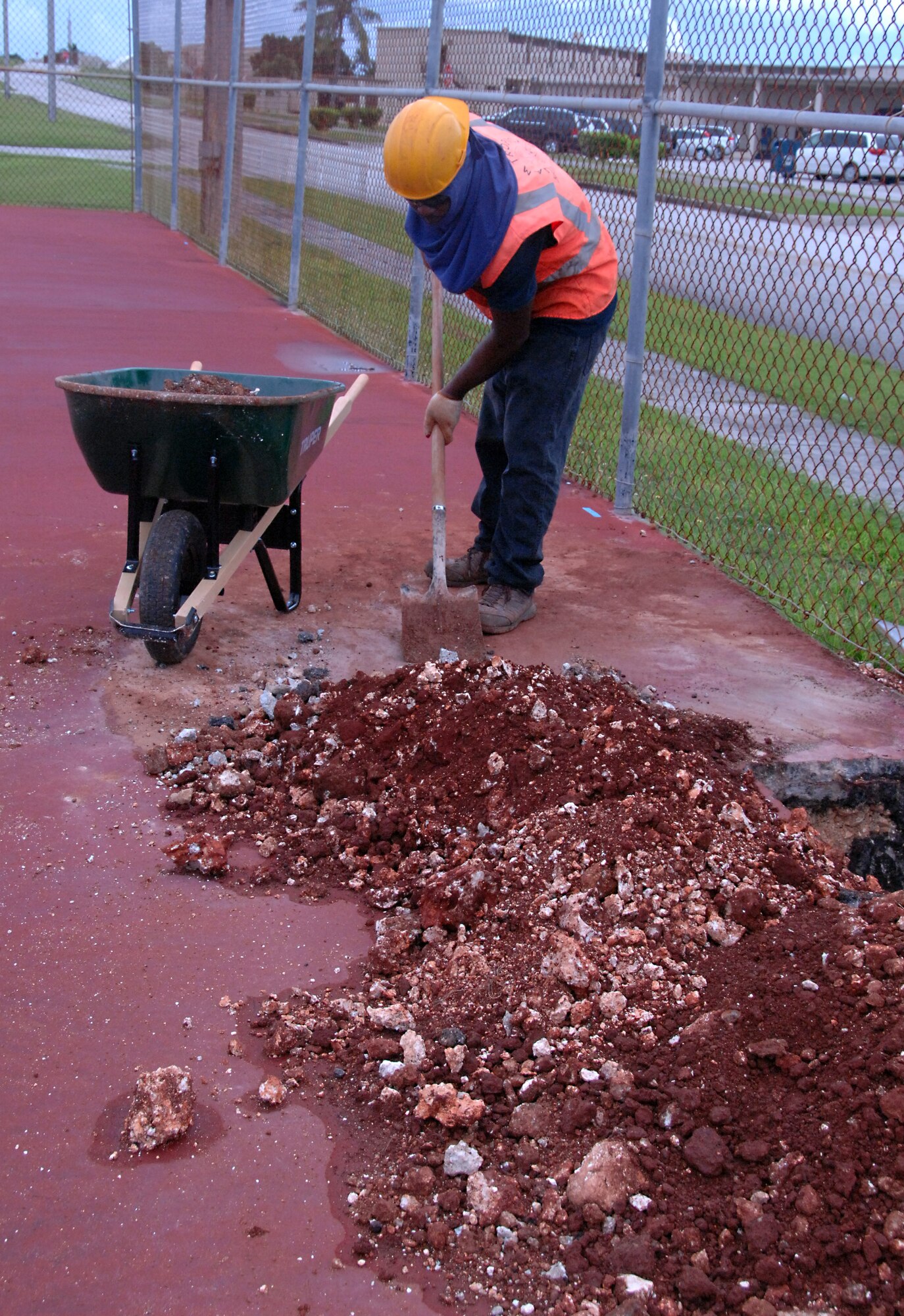 Haichy Sairia, a local contractor, clears rocks and gravel out of the tennis court Oct. 21 in support of a base-wide quality-of-life initiative. The tennis court is just one of many renovation projects to come in the effort to make Andersen Air Force Base a better place. (U.S. Air Force photo/Airman Whitney Amstutz)