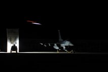 An aircraft takes off for a Max Thunder 10-2 night mission behind a U.S. Air Force F-16 Fighting Falcon parked on the flightline Oct. 20 at Kwangju Air Base, Republic of Korea. (U.S. Air Force photo/Staff Sgt. Eric Burks)