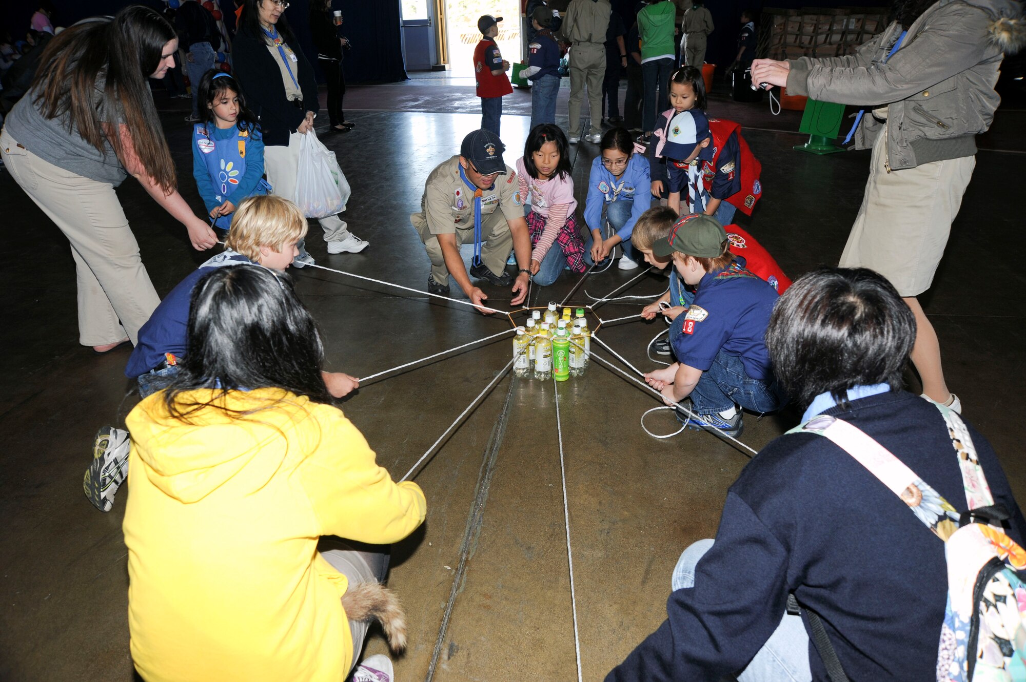 A bi-lateral team of American and Japanese Boy and Girl Scouts work together to lower a group of bottles with a rope device during International Scout Day at Misawa Air Base, Japan, Oct. 23, 2010.  There were 13 American Scout troops and 14 Japanese Scout troops that participated in the 51st annual event. (U.S. Air Force photo by Tech. Sgt. Russell McBride/Released)