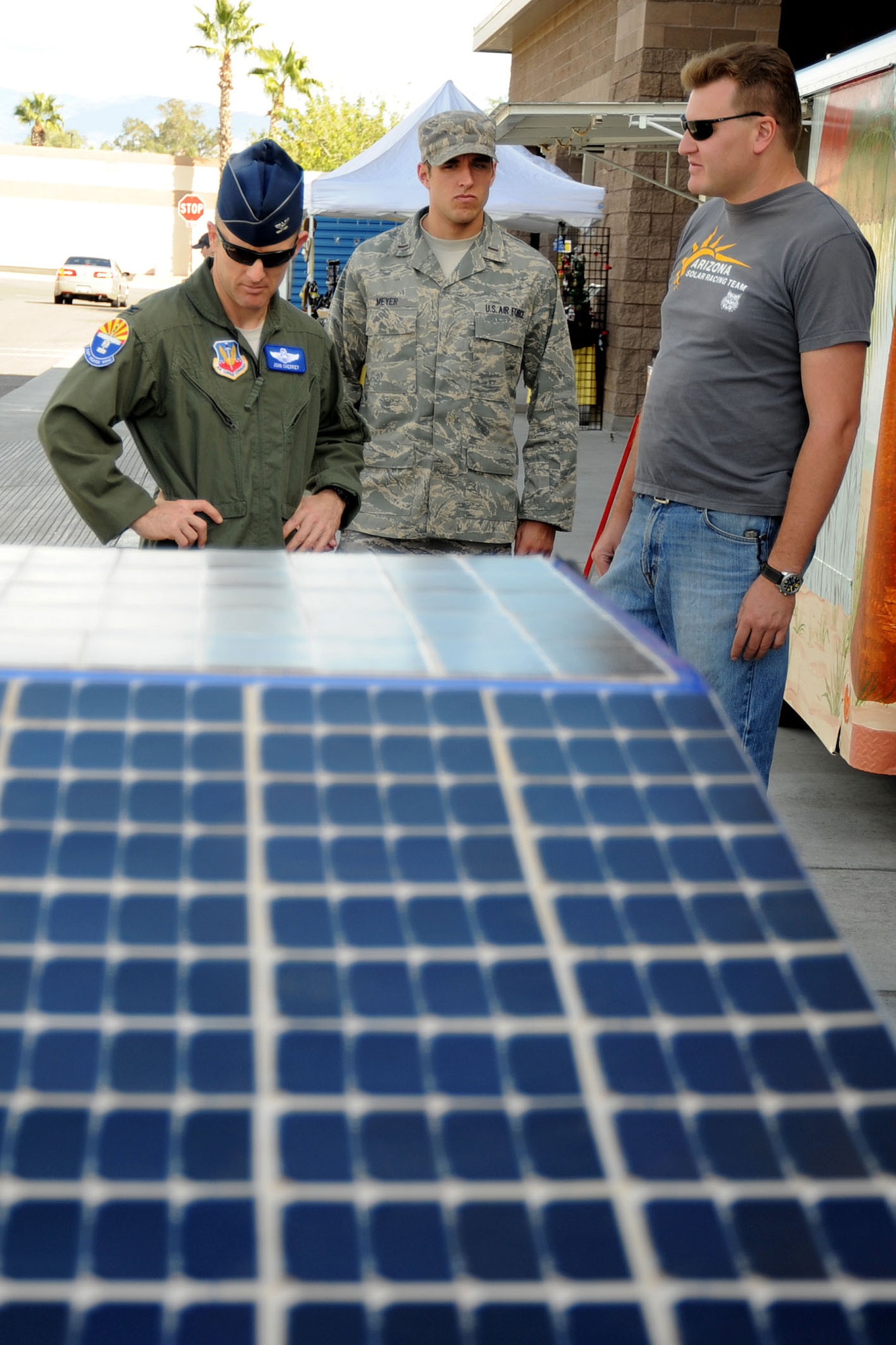 DAVIS-MONTHAN AIR FORCE BASE, Ariz. - Sean Martinez, University of Arizona graduate student in Systems Engineering, explains the U of A's solar car to Col. John Cherrey, 355th Fighter Wing commander, and 2nd Lt. Steven Meyer, 355th Civil Engineer Squadron officer in charge of operations support, Oct. 22 here. Mr. Martinez explained how the car took 10 months and roughly 400 "space grade" solar cells to build. It was built by U of A students as a project for an efficiency race. The race was not about speed, but about how efficient the car was with energy savings. The team unofficially came in second place. The team was disqualified from official rankings due to the vehicle being overweight. (U.S. Air Force photo/Tech. Sgt. Christopher Campbell)