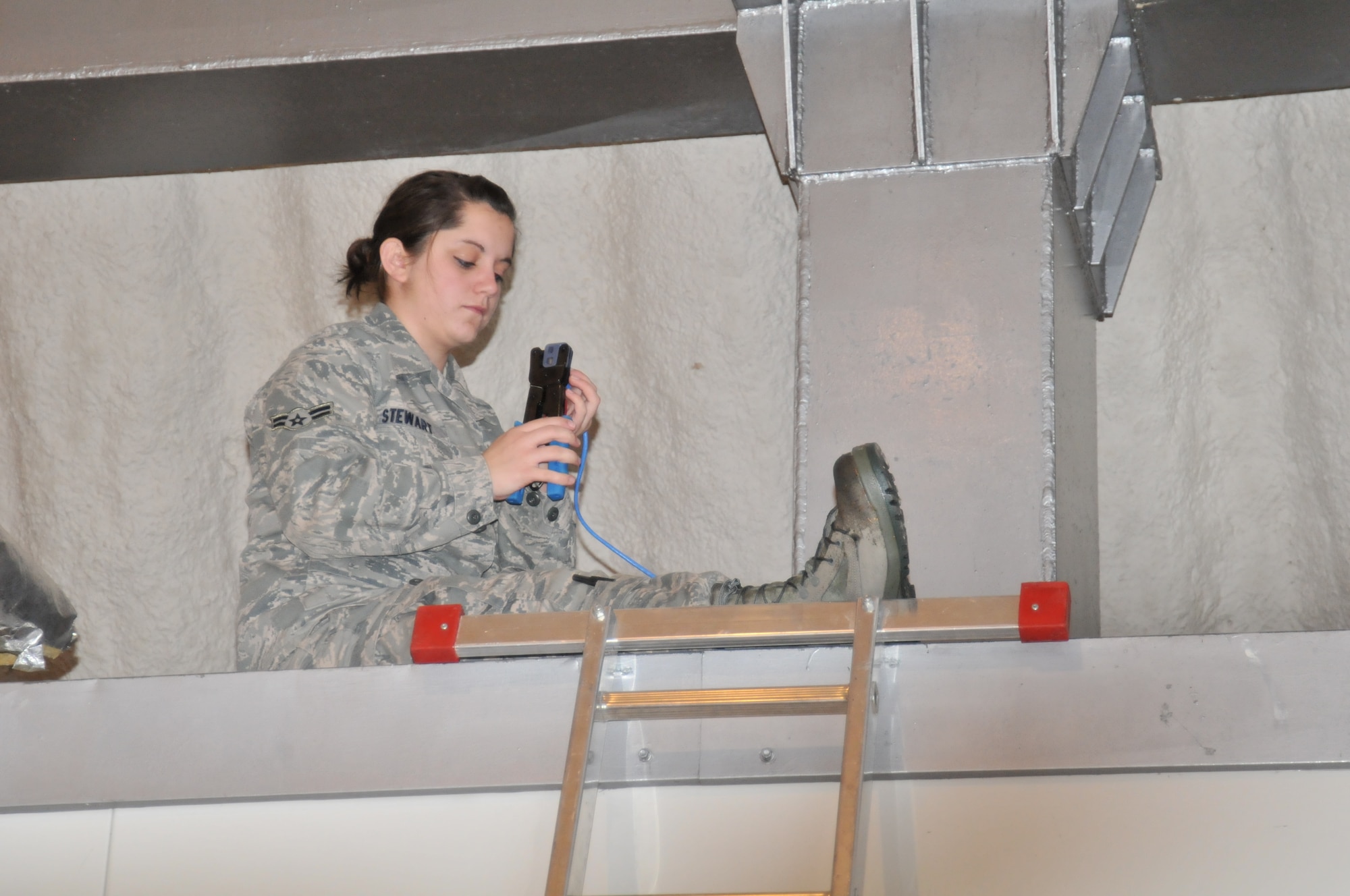 Airman Brittani Stewart of the 1st Combat Communications Squadron from Ramstein Air Base, Germany, installs cable infrastructure for maintenance personnel during preparations for Operation Golden Lance on Campia Turzii Air Base, Romania. The 1st CBCS was responsible for installing all official Internet and phone links for the American personnel participating in the exercise. (U.S. Air Force photo/Senior Airman David Dobrydney)