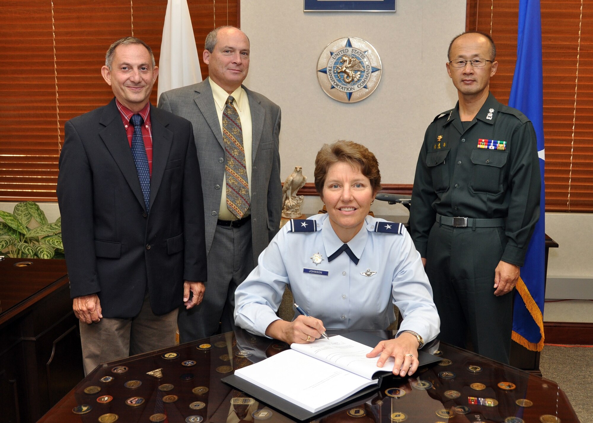Air Force Brig. Gen. Michelle Johnson, U.S. Transportation Command, director, Strategy, Policy, Programs and Logistics Directorate, signs the Implementing Arrangement to the United States - Republic of Korea Mutual Airlift Support Agreement as (left to right) Joe Lepanto, International Agreements manager, Kevin Spradling, director, International & Transportation Law, and Lt. Col. Steve Kim, ROK liaison officer to USTRANSCOM, look on. (Photo by Bob Fehringer, USTRANSCOM/PA)