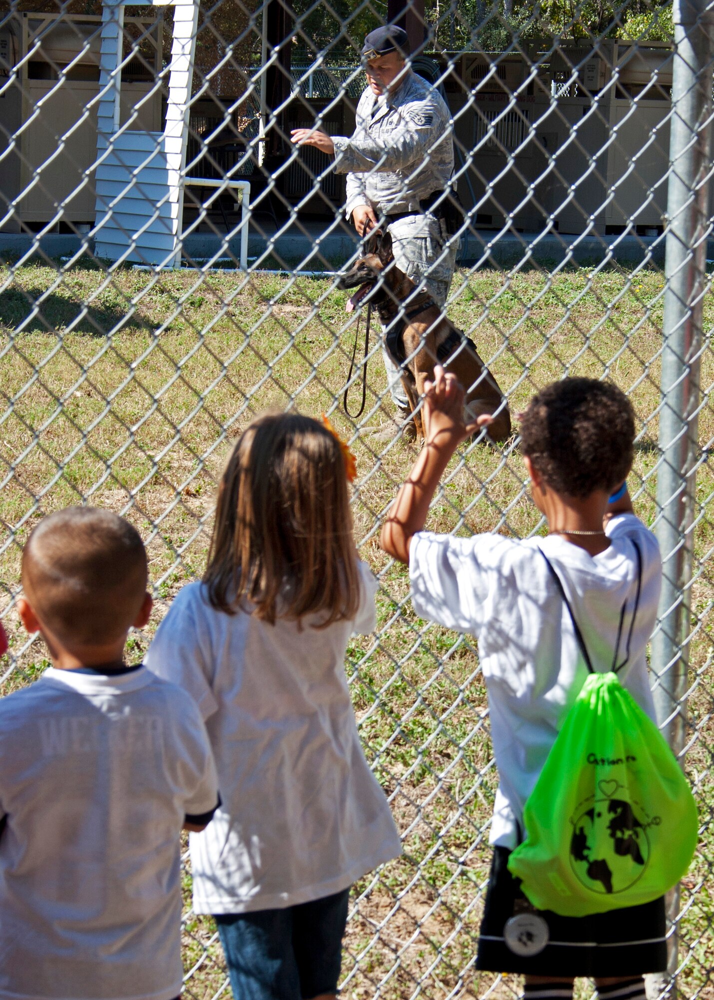 Children watch 96th Security Forces Squadron Staff Sgt. William Taulbee and his military working dog demonstrate of the animal's capabilities during Operation Hero Oct. 22 at Eglin Air Force Base, Fla.  Eglin organiztions showed children training and procedures their parents would go through during a deployment.  (U.S. Air Force photo/2nd Lt. Andrew Caulk.)