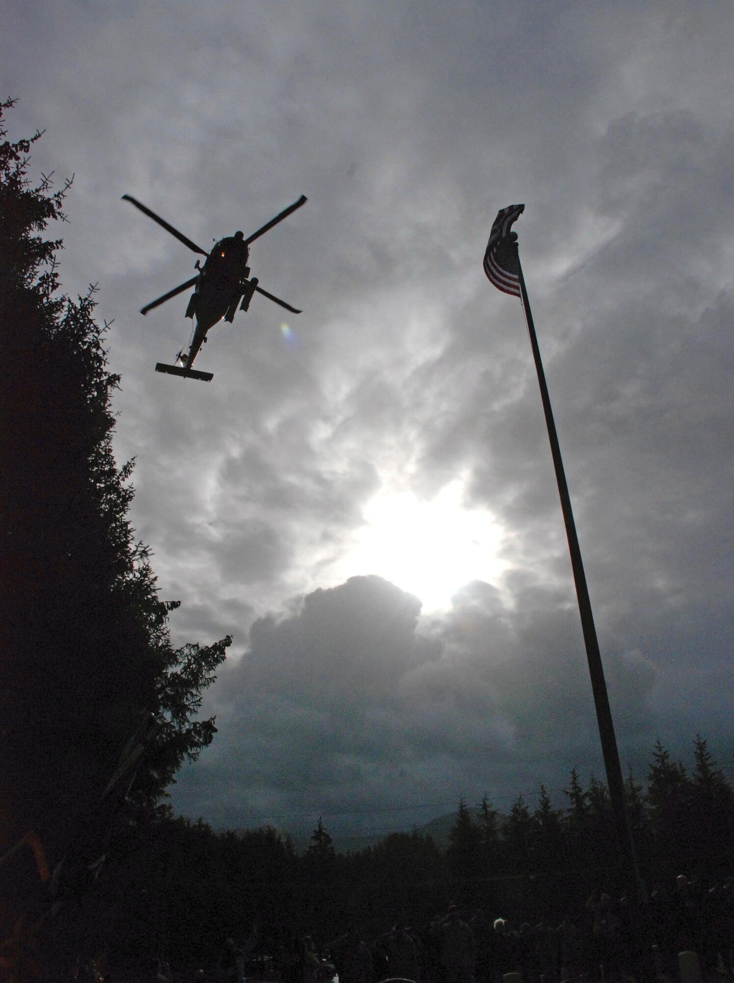 A Coast Guard helicopter performs a flyover of Sitka National Cemetery Monday during the annual Alaska Day Memorial Service. (U.S. Army photo/Mary Rall)