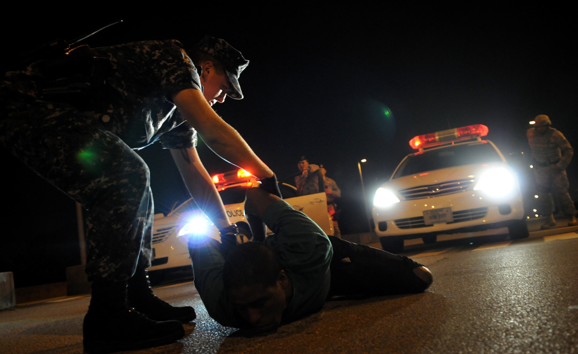 Petty Officer 3rd Class Justin Smith, a Master at Arms, attached to the 18th Security Forces Squadron apprehends a suspect who allegedly "robbed" a convenience store as part of an exercise, at Kadena Air Base, Japan Oct. 25. Kadena personnel are participating in Exercise Beverly High 11-01 to stay prepared for real world contingencies. (U.S. Air Force photo/Airman 1st Class Jarvie Z. Wallace)