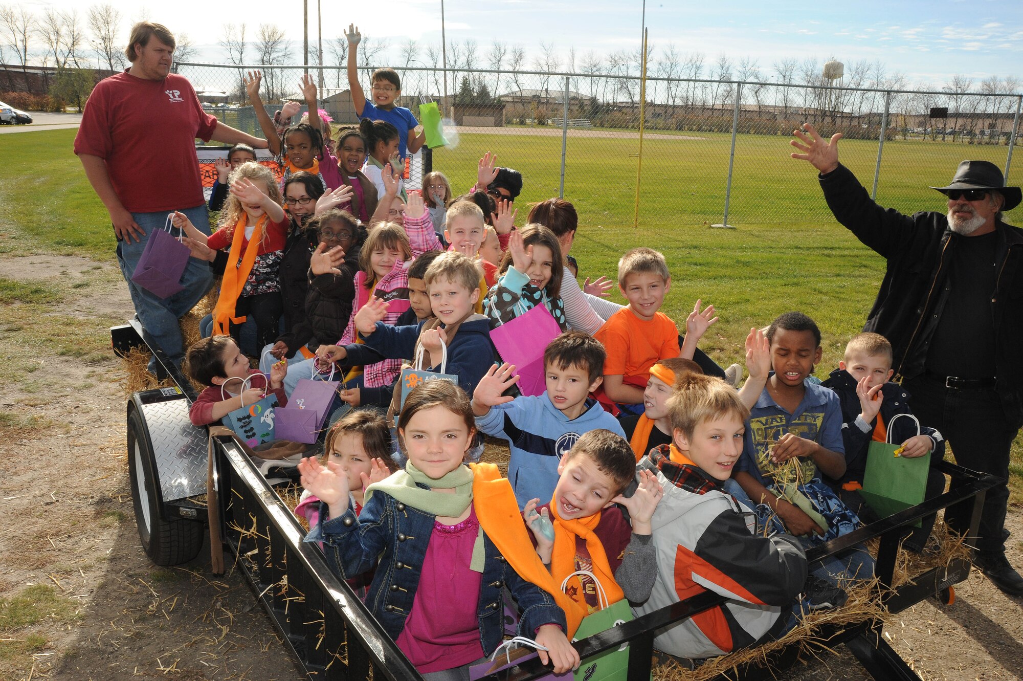 Children from the Grand Forks Air Force Base community, wave at the camera before going on a hayride Oct. 21 during Fall Fest on Grand Forks Air Force Base, N.D. Fall Fest included various events to boost the morale of servicemembers and their families. The 319th Operations Support Squadron won the grand prize drawing of $300. (U.S. Air Force photo by Tech. Sgt. Johnny Saldivar)