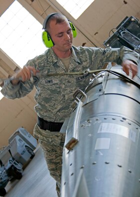 Senior Airman Randy Lewis, 46th Maintenance Squadron Red, tightens down the strap on a Joint Direct Attack Munition during the quarterly weapons load competition Oct. 22.  Load crews were judged in four areas:  dress and appearance, knowledge of their specialty, tools and equipment, and accuracy, safety and reliability of the actual weapons load.  The Blue AMU team of Staff Sgt. Alison Kline, Senior Airman Krystle Orth, and Senior Airman Ryan Corley won the competition with a time of 38 minutes, 22 seconds.  (U.S. Air Force photo/2nd Lt. Andrew Caulk.)
