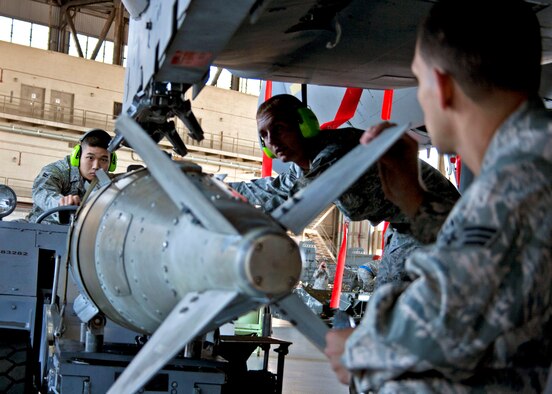 (Middle) Senior Airman Randy Lewis watches as Airman 1st Class Eugene Lee, 46th Maintenance Squadron Red, “parks” the Joint Direct Attack Munition under the F-15 during the quarterly weapons load competition Oct. 22.  Load crews were judged in four areas:  dress and appearance, knowledge of their specialty, tools and equipment, and accuracy, safety and reliability of the actual weapons load.  The Blue AMU team of Staff Sgt. Alison Kline, Senior Airman Krystle Orth, and Senior Airman Ryan Corley won the competition with a time of 38 minutes, 22 seconds.  (U.S. Air Force photo/2nd Lt. Andrew Caulk.)