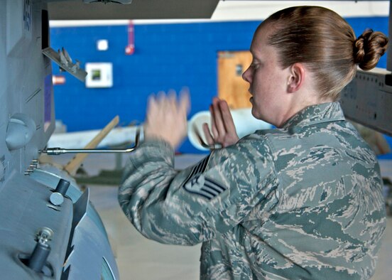Staff Sgt. Alison Kline, 46th Maintenance Squadron Blue, tightens down a screw to hold the weapon in place on an F-15 during the quarterly weapons load competition, Oct. 22.  Load crews were judged in four areas:  dress and appearance, knowledge of their specialty, tools and equipment, and accuracy, safety and reliability of the actual weapons load.  The Blue AMU team of Sergeant Kline, Senior Airman Krystle Orth, and Senior Airman Ryan Corley won the competition with a time of 38 minutes, 22 seconds.  (U.S. Air Force photo/2nd Lt. Andrew Caulk.)