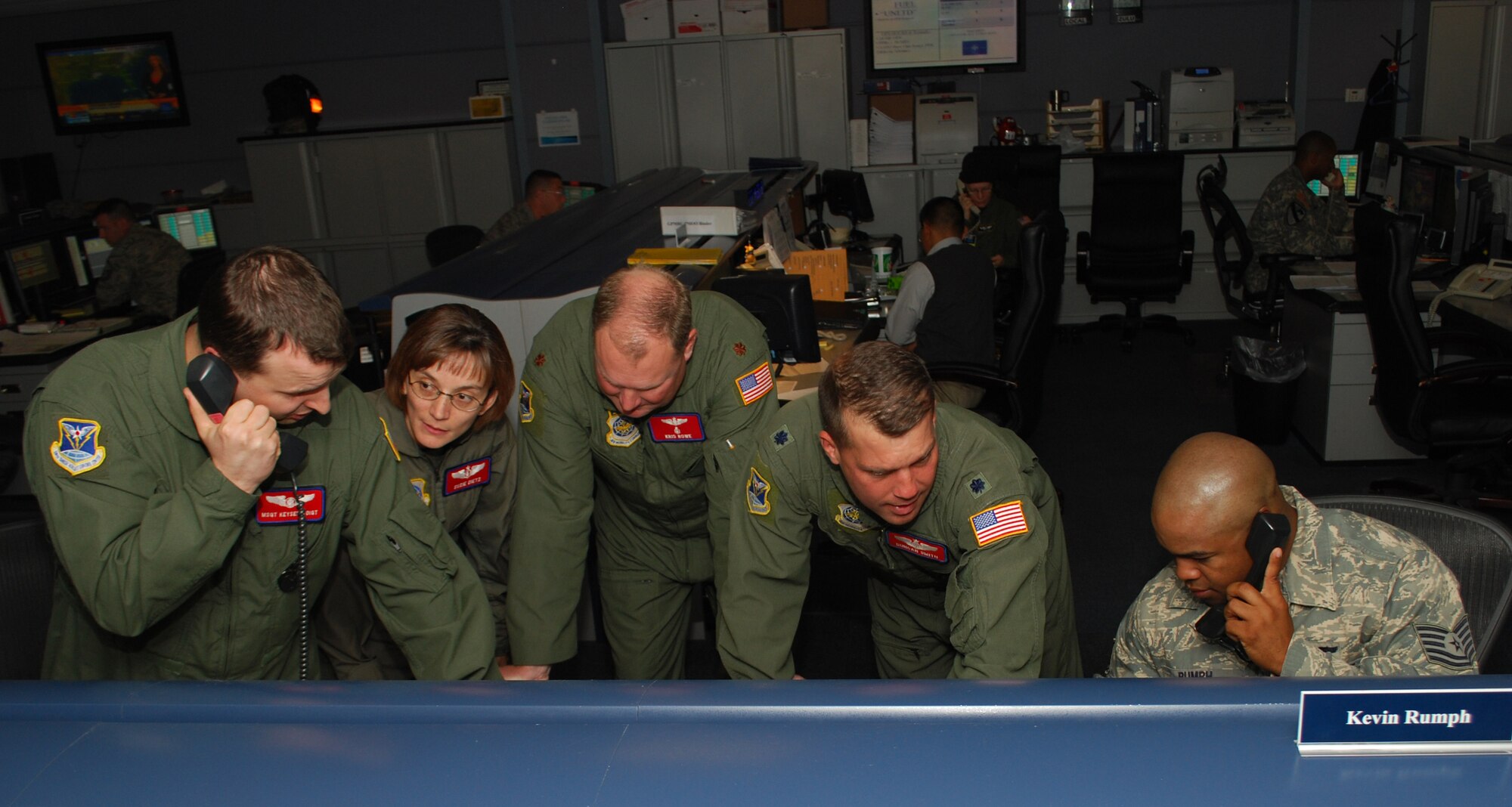 From left to right: Master Sgt. Keyser Voigt, Maj. Susie Dietz, Maj. Kris Rowe, Lt. Col. Duncan Smith, and Tech. Sgt. Kevin Rumph, discuss the details of aeromedical evacuation missions planned for the day on the 618th AOC’s operations floor.  The 618th AOC coordinates multiple AE flights daily to transport injured servicemembers and civilians to further medical care around the world. (U.S. Air Force Photo/Capt. Justin Brockhoff)