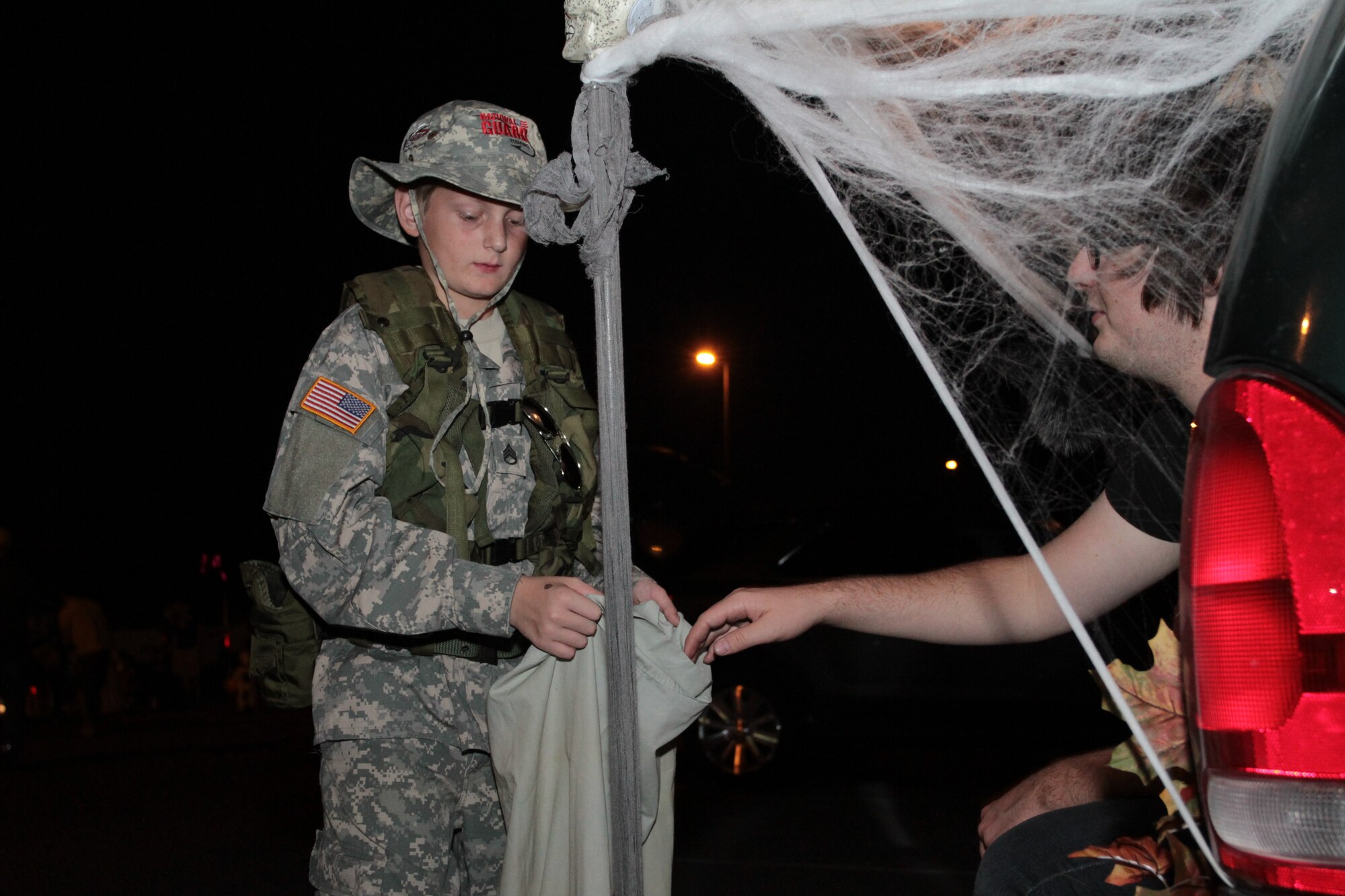 (Right) Josh Horne, son of Lt. Col. Debbie Horne, 19th Force Support Squadron commander, hands candy to (left) Stephen Hairston, 11, son Army Master Sgt. Timothy Hairston and Army Staff Sgt. Kimberly Hairston, Oct. 23 during the base’s Trunk-or-Treat. People decorated the trunks of their vehicles and handed out candy to military families. (U.S. Army photo by Spc. Jared Sollars)