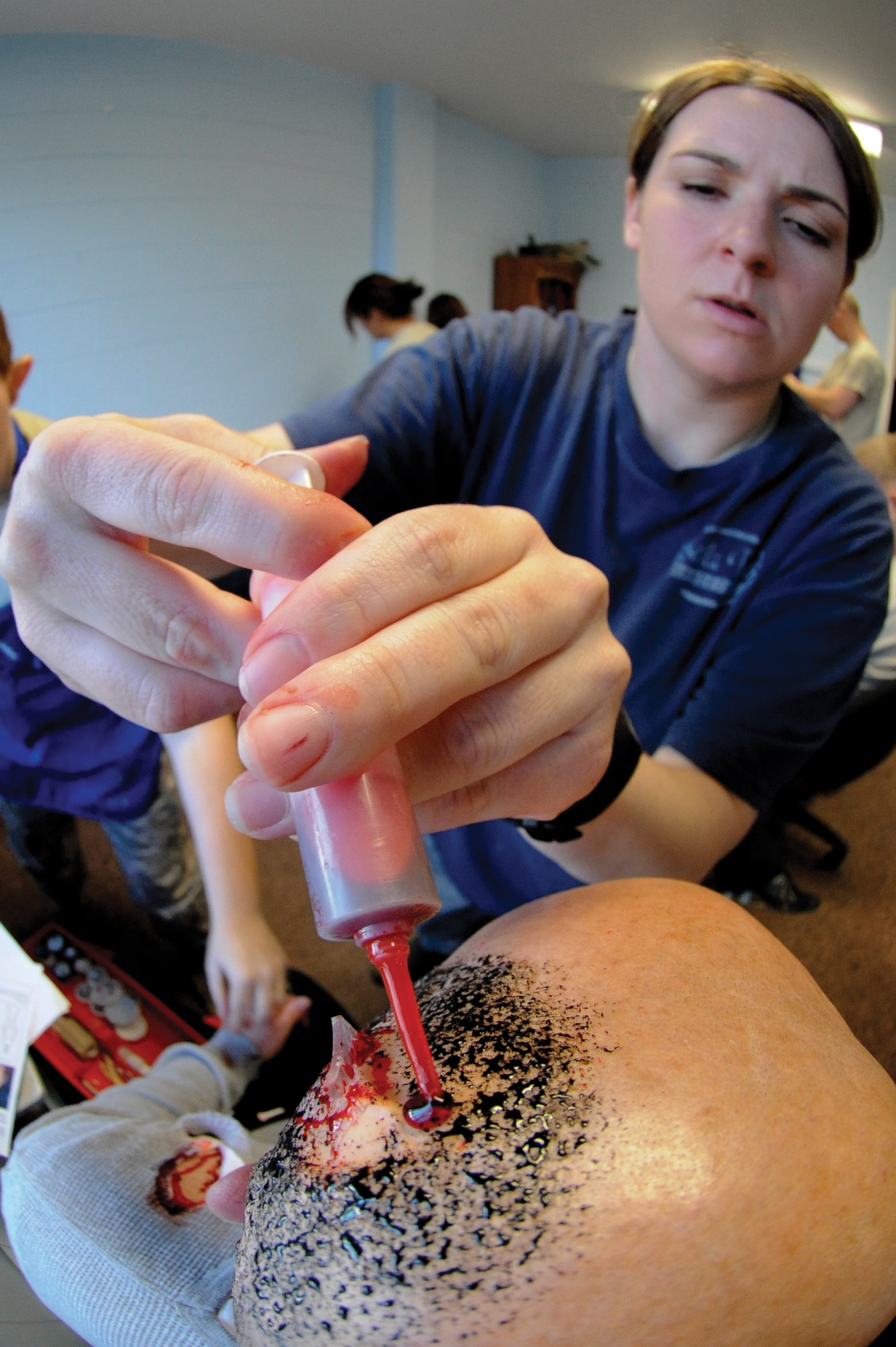 Capt. Tamarah Murphy 673d Surgical Operations Squadron, applies moulage to Staff Sgt. Brad Maxwell, 673d Air Base Wing Judge Advocate Office, prior to an Emergency Management Exercise at Joint Base Elmendorf-Richardson, Alaska, October 19. The moulage provides visual indicators of wounds for the first responders during the EME. (U.S. Air Force photo/Staff Sgt. Joshua Garcia)
